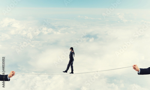 Business concept of risk support and assistance with man balancing on rope © adam121