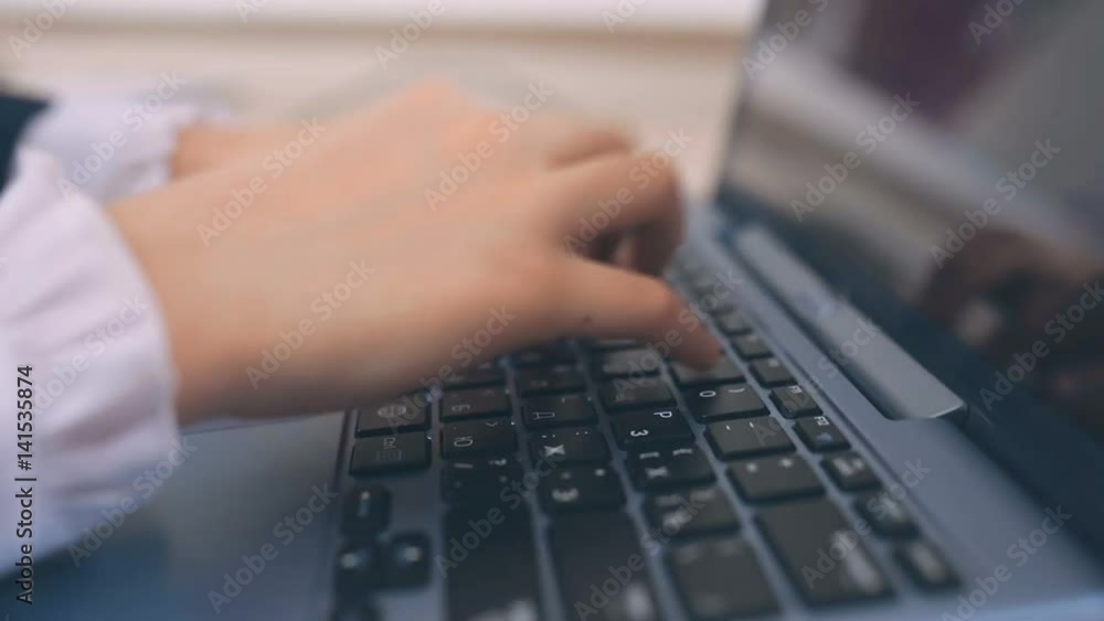 The little businessgirl presses the buttons on the keyboard The little businessgirl presses the buttons on the keyboard