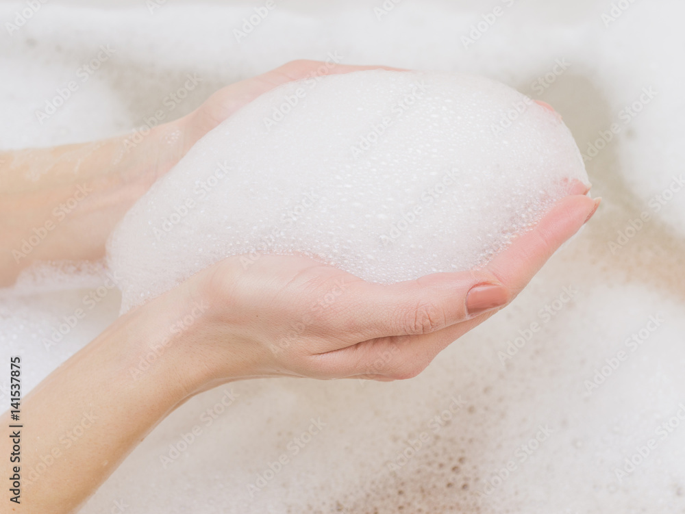 Fototapeta premium Beautiful female hands in white soap.