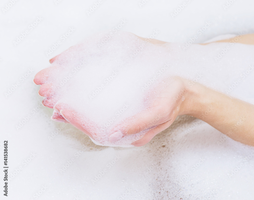 Fototapeta premium Beautiful female hands in white soap.