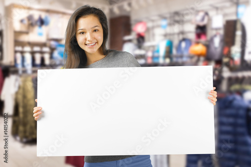 Beautiful young woman holding blank card.