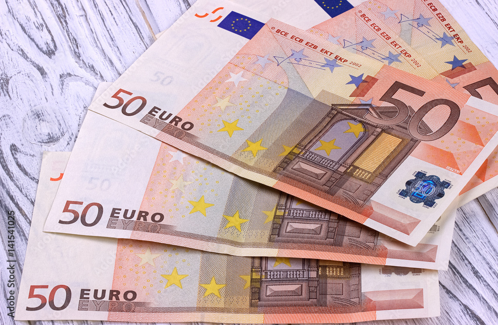 Fifty euro banknotes on white wooden background. Fifty euro banknotes on white wooden background.