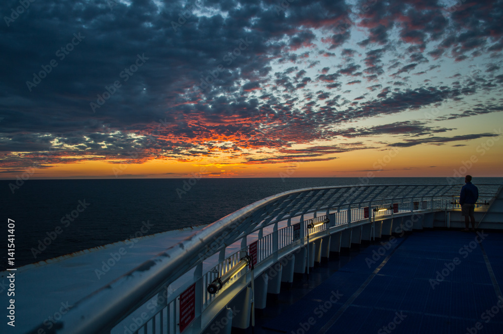 A Man Watching the Sunrise over the Atlantic on Deck of the Ferry between Novia Scotia and Newfoundland, Canada