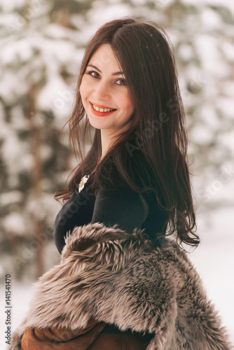 young beautiful girl in a fur coat walks in the Park