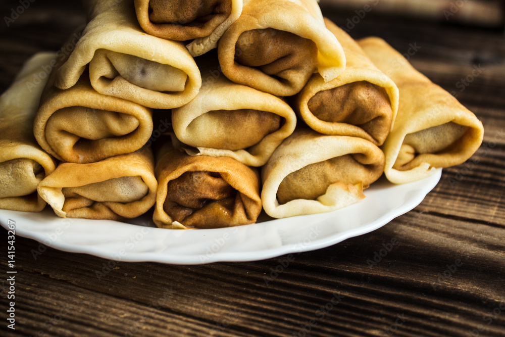stuffed crepe stacked on white plate stuffed crepe stacked on white plate