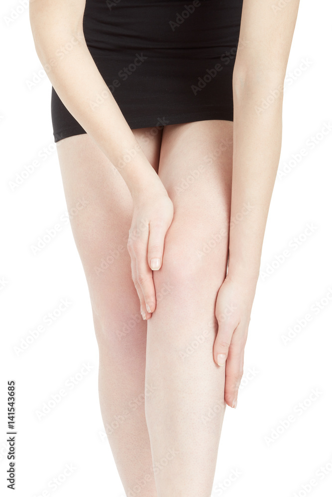 Young woman with black dress touching her tired leg isolated on white, clipping path
