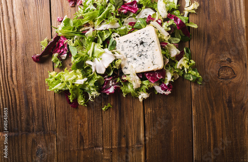 Salad mix on a wooden background. Ingredients for salad. A slice of blue cheese. Salad