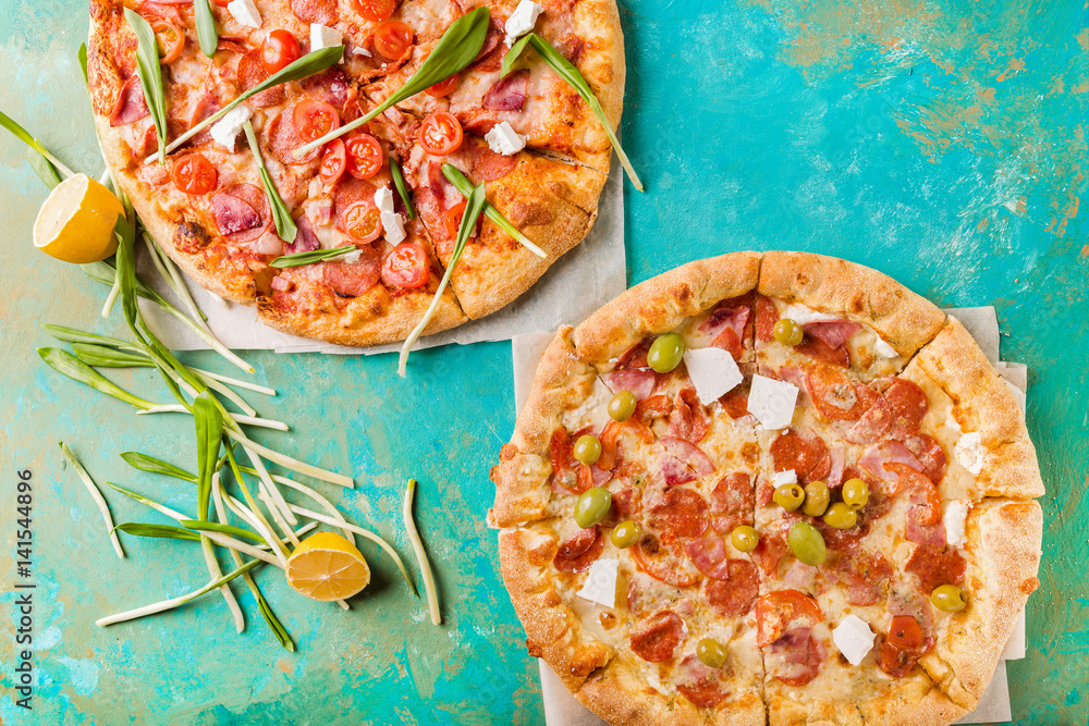 Spring pizza. Salami pizza. Pizza salami on a turquoise abstract
