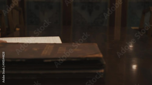 Wallpaper Mural Panoramic shot an old woman thumb through book russian cursive text on table Torontodigital.ca