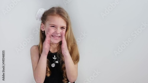 The girl claps her hands joyfully. The girl smiles and starts clapping