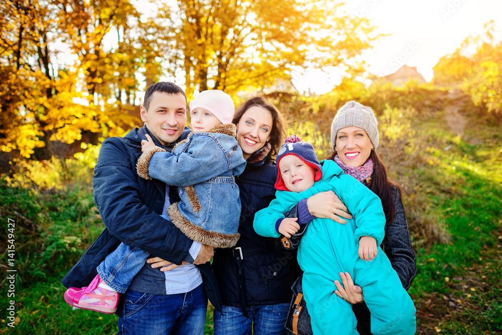 Young family, parents with small children in golden autumn city park Young family, parents with small children in golden autumn city park