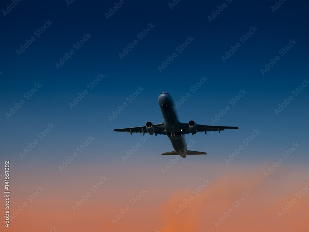 Aircraft take-off from airport at sunset time. Air transportation and overnight flight theme.