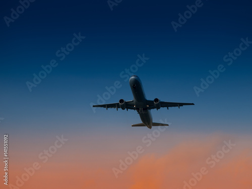 Aircraft take-off from airport at sunset time. Air transportation and overnight flight theme.