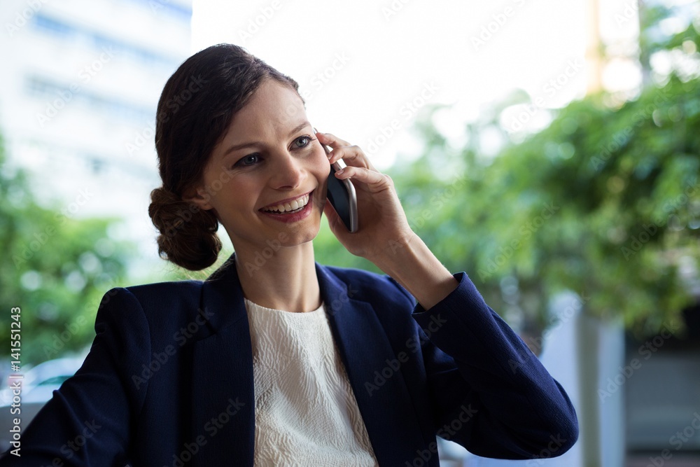 Businesswoman talking on mobile phone in cafe Businesswoman talking on mobile phone in cafe