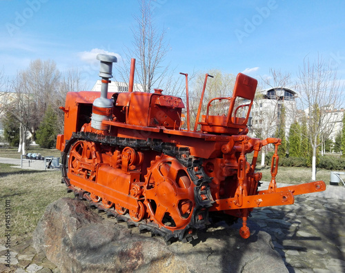 An old tractor on a stone in park