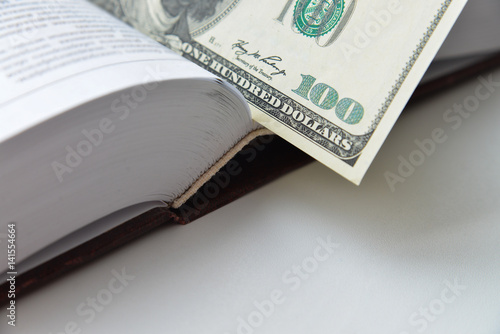 Dollar bill used as a bookmark in a book