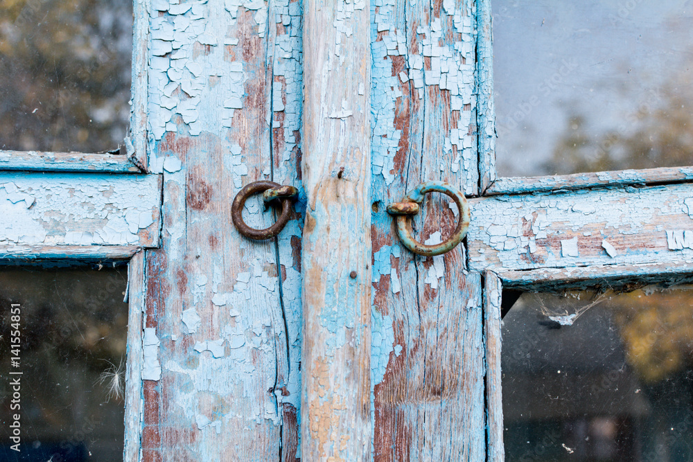 Eyelets castle on the old wooden door is blue, the paint is crumbling Eyelets castle on the old wooden door is blue, the paint is crumbling