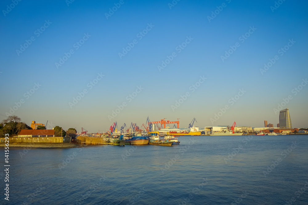 SHANGHAI, CHINA: Shanghai riverbank, industrial boats and some port facilities lying waterfront, beautiful blue sky
