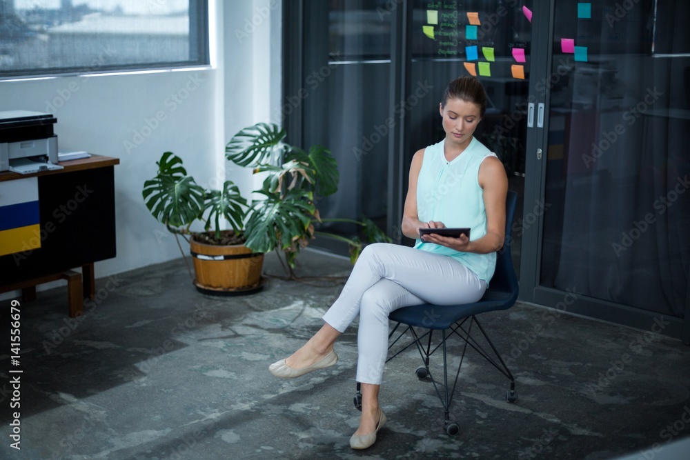 Graphic designer sitting on chair and using digital tablet Graphic designer sitting on chair and using digital tablet