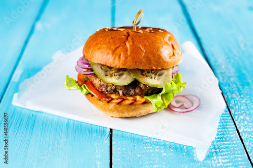 Delicious Turkey burgers with salad on a rustic wooden table