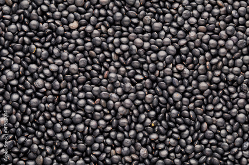 Food and cookery background of healthy dried black lentils.