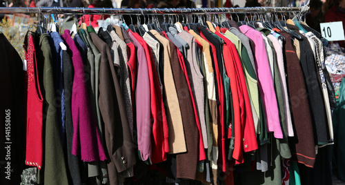 clothes hung from hangers for sale in flea market
