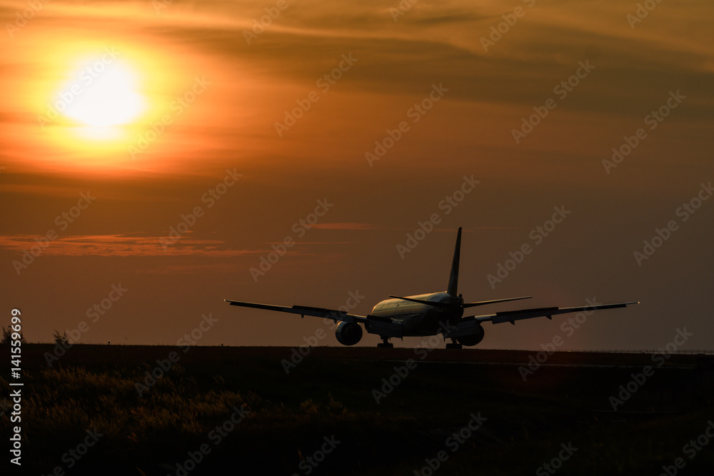 Airplane on runway in sunset