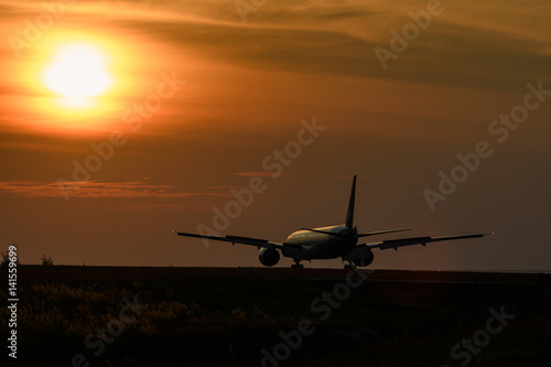 Airplane on runway in sunset