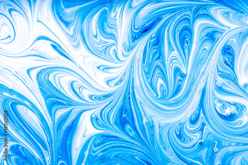 Blue and white paint mixing making swirls background. Stock Photo