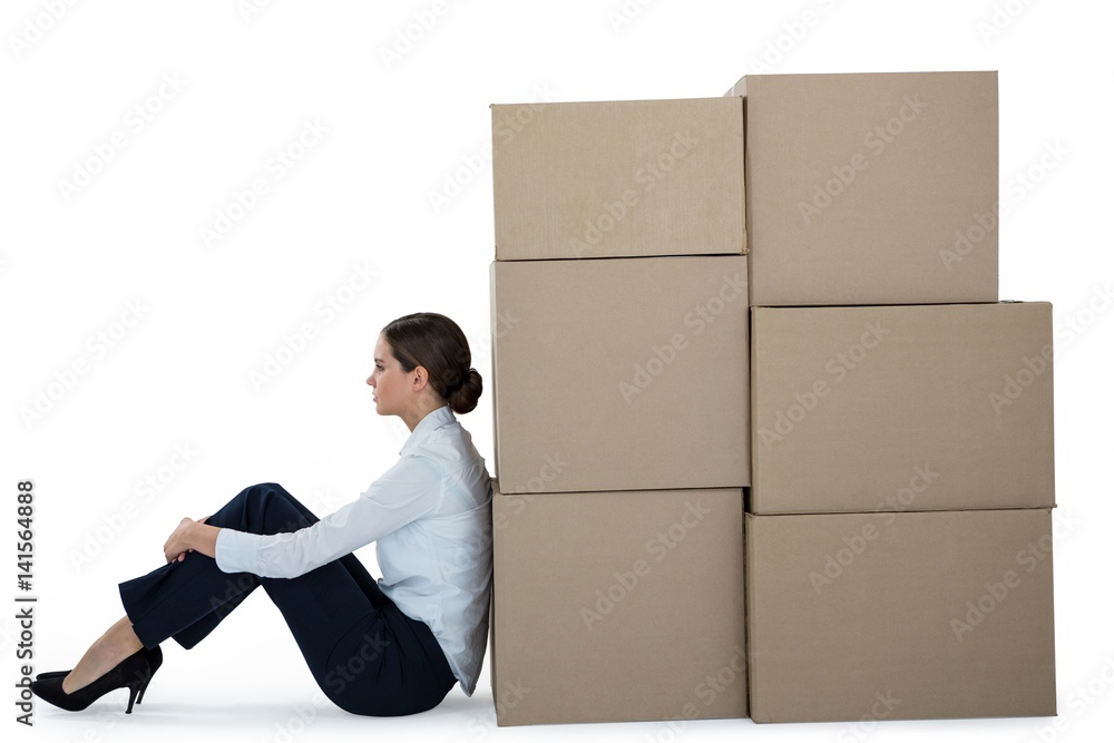 Businesswoman leaning on cardboard boxes Businesswoman leaning on cardboard boxes