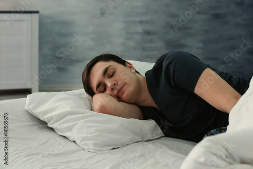 Young tired man sleeping in...
