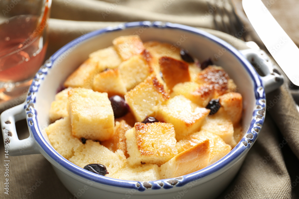 Delicious bread pudding with currant in bowl on napkin Delicious bread pudding with currant in bowl on napkin