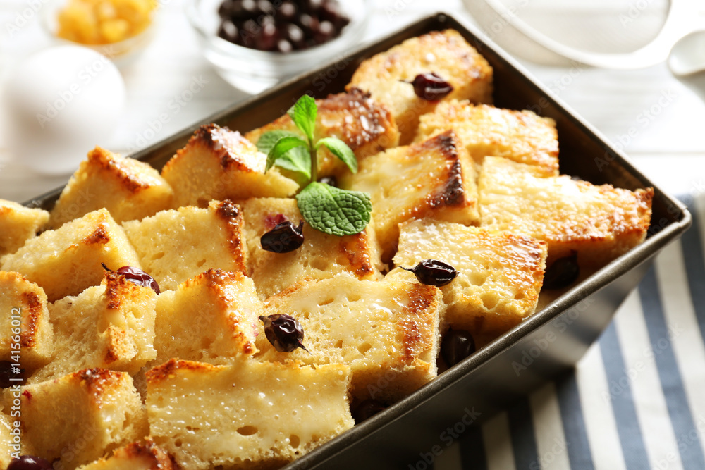 Delicious bread pudding with currant in baking dish on kitchen table Delicious bread pudding with currant in baking dish on kitchen table