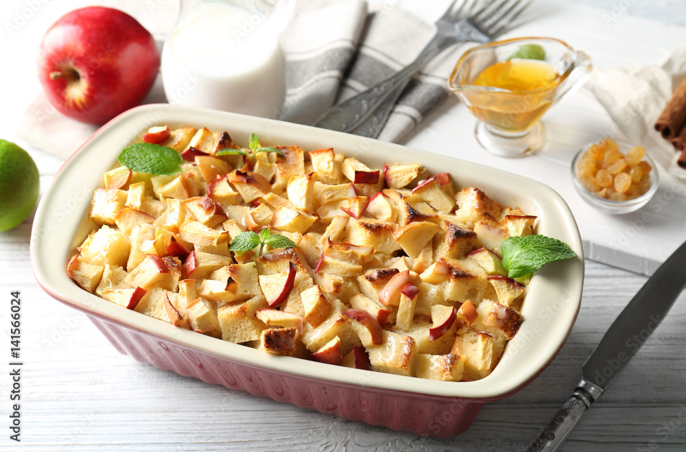Tasty bread pudding with apples in baking dish on table Tasty bread pudding with apples in baking dish on table