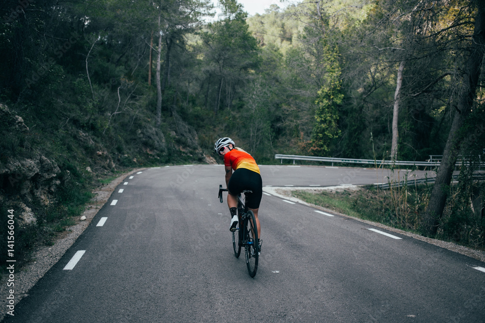 Female girl cyclist riding in the mountains and trees of spain Female girl cyclist riding in the mountains and trees of spain