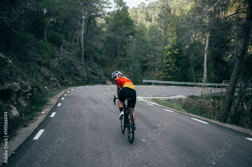 Female girl cyclist riding in the mountains and trees of spain