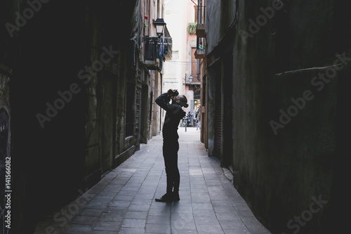 hipster in alley taking photo