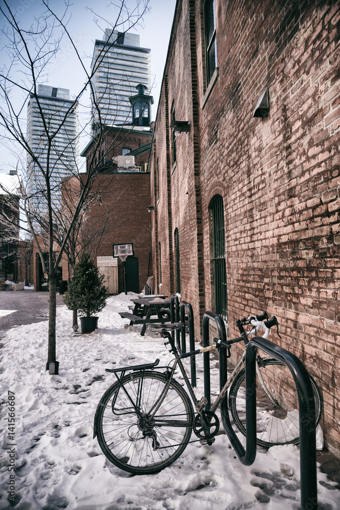 Bicycle in winter near brick wall