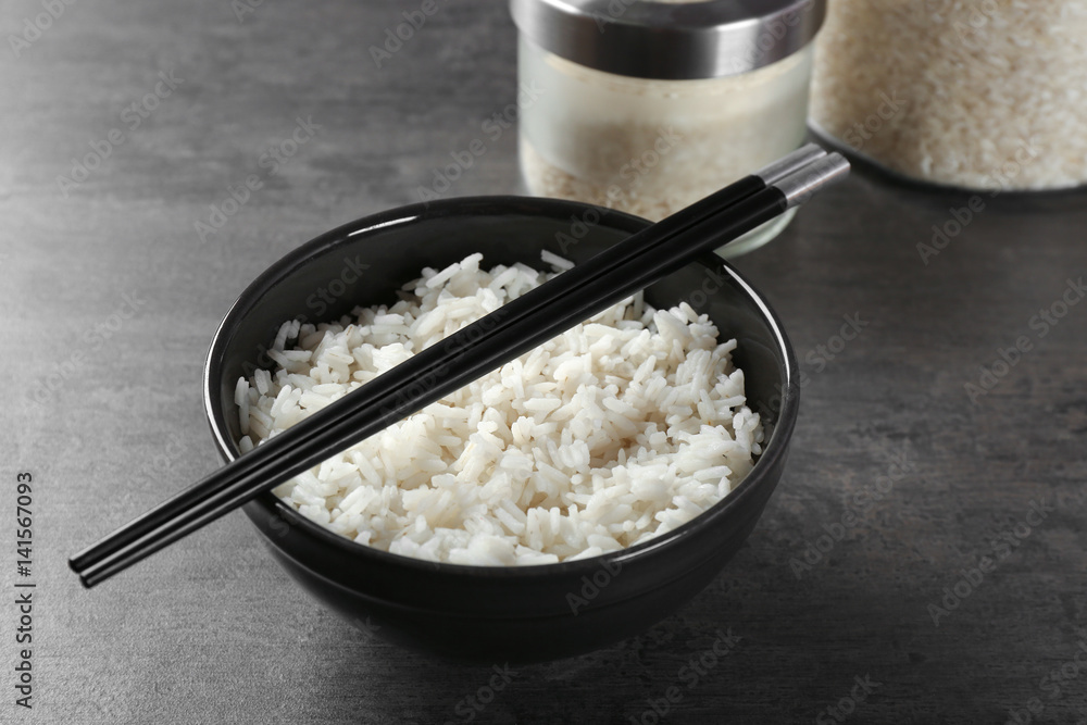 Bowl of rice and chopsticks on color background Stock Photo | Adobe Stock