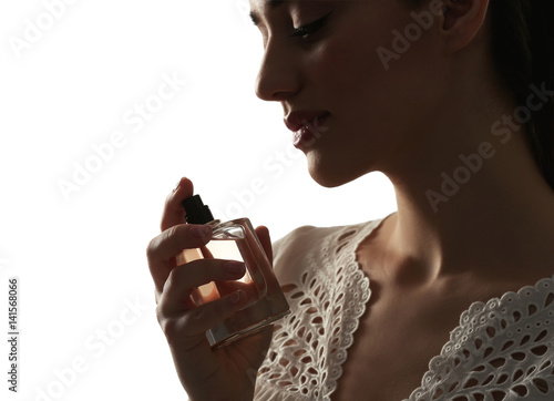 Beautiful young woman with bottle of perfume on white background, closeup