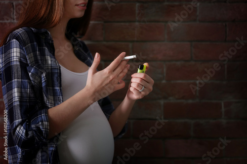 Pregnant woman smoking ciga...