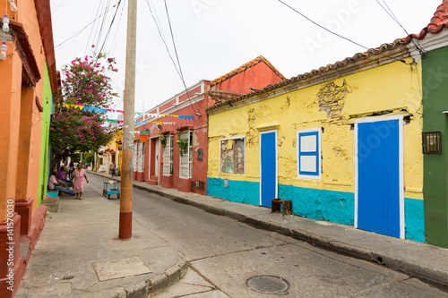 CARTAGENA, COLOMBIA - MAY 24: Unidentified people walk past brightly painted colonial era houses in the Getsemani neighborhood of Cartagena, Colombia on May 24, 2016.