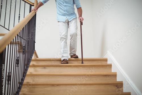 Canvastavla Senior man climbing downstairs with walking stick
