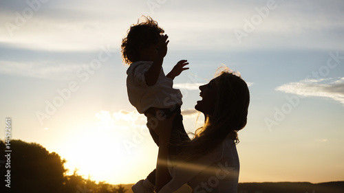 Silhouette of a young mother with her little child.