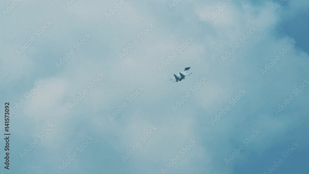 An su-35 Fighter Jet flying high above the clouds. Russian fighter flies a dangerous maneuver An su-35 Fighter Jet flying high above the clouds. Russian fighter flies a dangerous maneuver