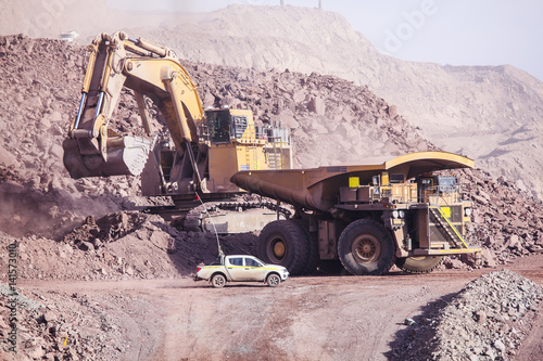 Big shovel loading of copper ore near to pickup truck photo