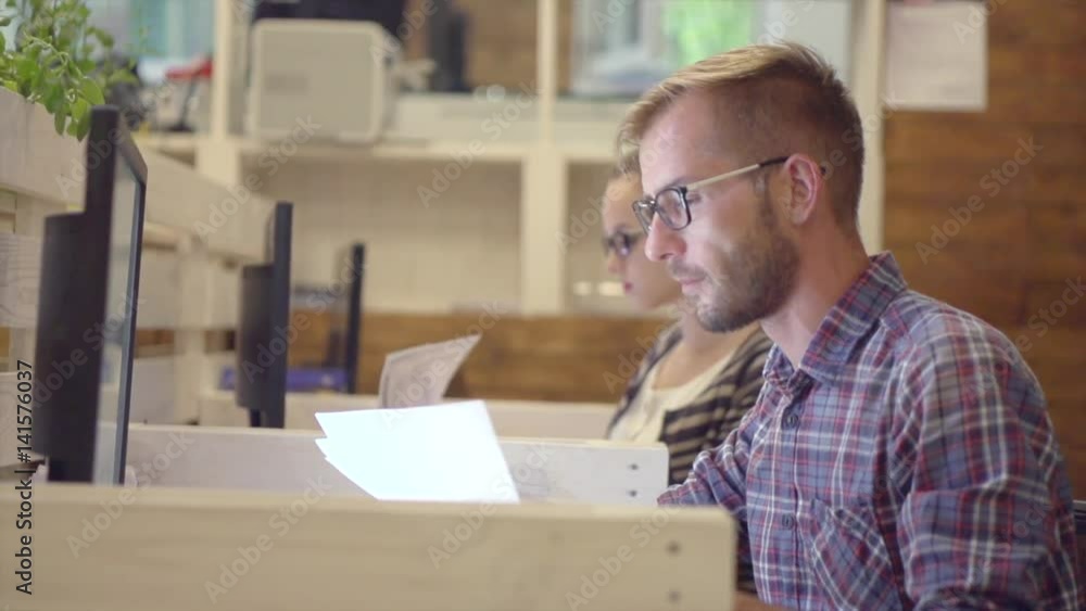Young casual business couple using computer in the office. Slow motion 240 fps. 4K UHD video Young casual business couple using computer in the office. Slow motion 240 fps. 4K UHD video