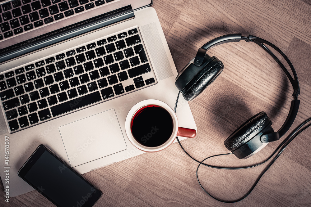 Coffee time. A cup of coffee at the phone's laptop and headphones Coffee time. A cup of coffee at the phone's laptop and headphones
