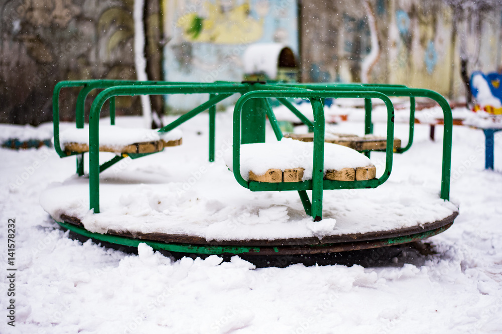 Snow in the spring. Children's carousel covered with snow Snow in the spring. Children's carousel covered with snow