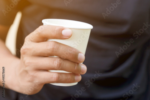Man holding hot coffee paper cup.